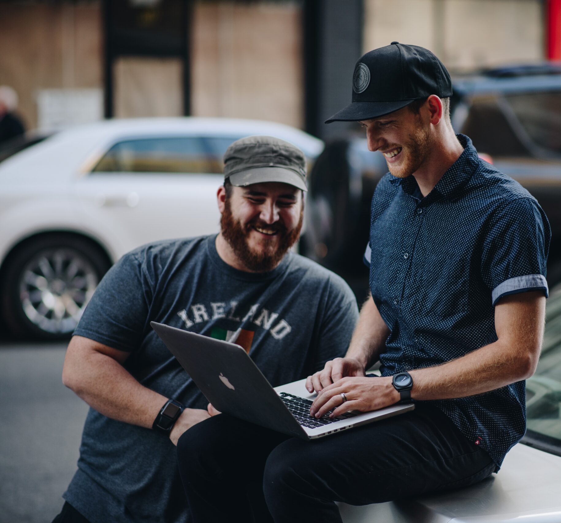 two-men-laughing-and-working-on-their-laptop_t20_doE7yJ-scaled-e1590124390236